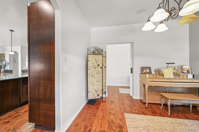 2373 S Joyce St, Denver, CO 80228 - corridor featuring arched walkways, wood finished floors, baseboards, a chandelier, and lofted ceiling