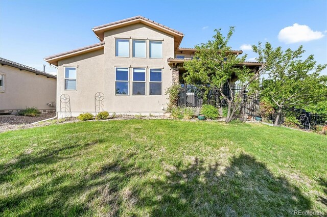 2373 S Joyce St, Denver, CO 80228 - view of front of home with a front lawn, stucco siding, and a tile roof