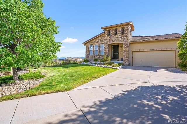 2373 S Joyce St, Denver, CO 80228 - mediterranean / spanish-style house with stone siding, driveway, an attached garage, a tile roof, and stucco siding
