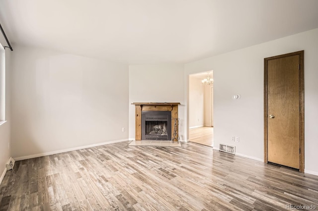 3021 11th Ave Unit 15, Evans, CO 80620 - unfurnished living room with wood finished floors, a chandelier, and baseboards