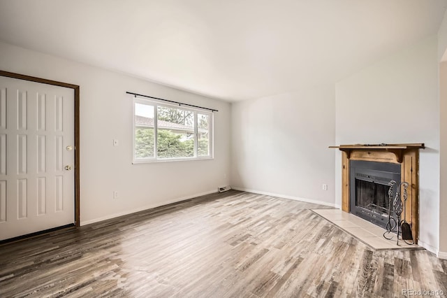 3021 11th Ave Unit 15, Evans, CO 80620 - unfurnished living room with wood finished floors, a tiled fireplace, and baseboards