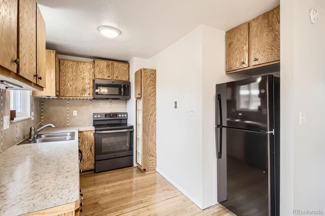 3021 11th Ave Unit 15, Evans, CO 80620 - kitchen featuring freestanding refrigerator, electric stove, a sink, light wood finished floors, and backsplash