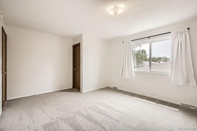 3021 11th Ave Unit 15, Evans, CO 80620 - unfurnished room with a textured ceiling, carpet flooring, and baseboards