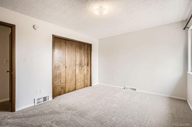 3021 11th Ave Unit 15, Evans, CO 80620 - unfurnished bedroom featuring carpet flooring, a closet, a textured ceiling, and baseboards