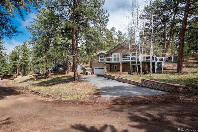 5382 S Pine Rd, Evergreen, CO 80439 - view of front of home with asphalt driveway, a garage, stairs, a wooden deck, and a chimney
