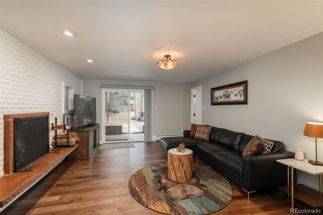 5382 S Pine Rd, Evergreen, CO 80439 - living area featuring brick wall, wood finished floors, a baseboard heating unit, recessed lighting, and a fireplace