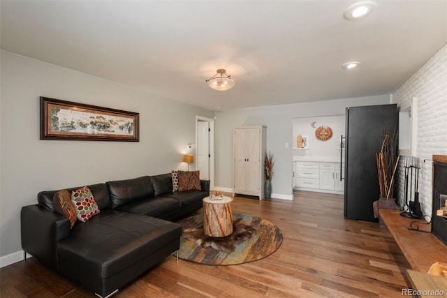 5382 S Pine Rd, Evergreen, CO 80439 - living room with wood finished floors, baseboards, and a brick fireplace