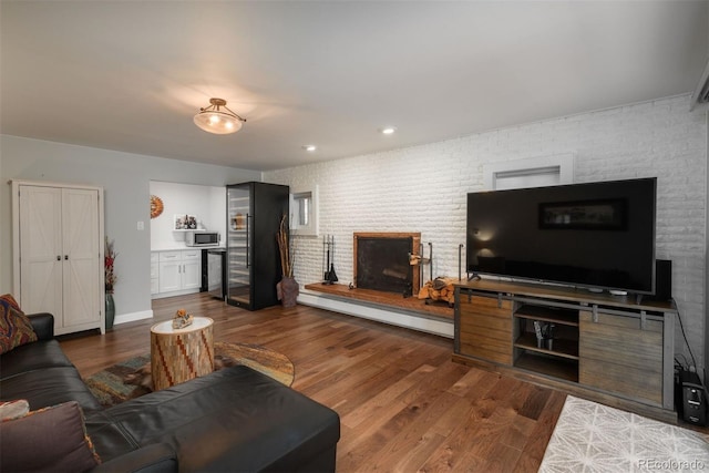 5382 S Pine Rd, Evergreen, CO 80439 - living area featuring a fireplace with raised hearth, wood finished floors, and brick wall
