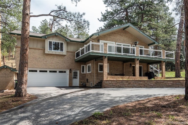 5382 S Pine Rd, Evergreen, CO 80439 - view of front of house featuring driveway, a garage, brick siding, board and batten siding, and stairway