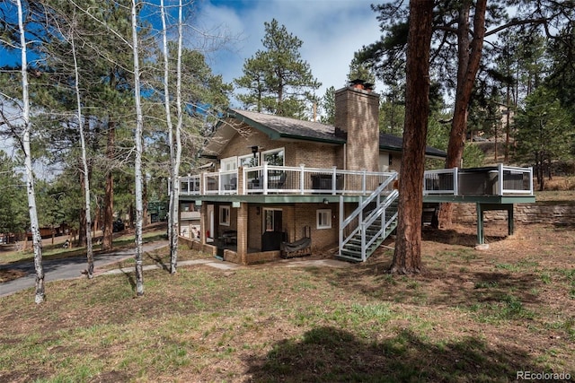 5382 S Pine Rd, Evergreen, CO 80439 - back of house with brick siding, a deck, a chimney, and stairs