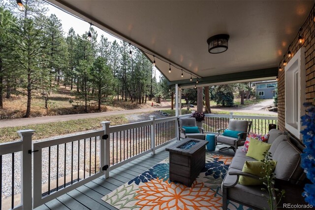 5382 S Pine Rd, Evergreen, CO 80439 - wooden terrace with an outdoor living space with a fire pit and a porch
