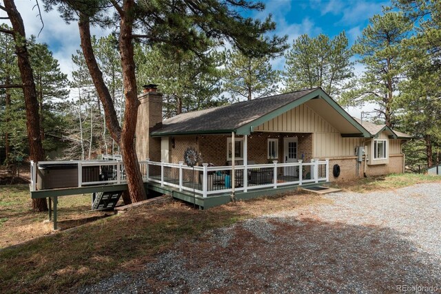 5382 S Pine Rd, Evergreen, CO 80439 - chalet / cabin featuring brick siding, board and batten siding, a chimney, a shingled roof, and a wooden deck