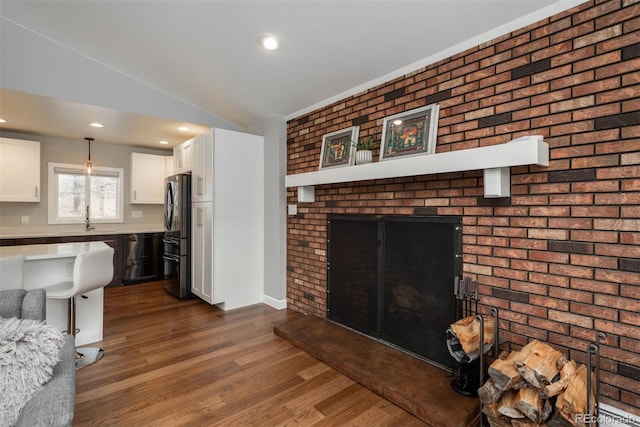 5382 S Pine Rd, Evergreen, CO 80439 - living room featuring dark wood finished floors, vaulted ceiling, recessed lighting, and brick wall