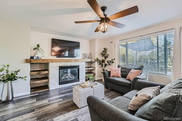 living room featuring a fireplace, baseboards, ceiling fan, and wood finished floors