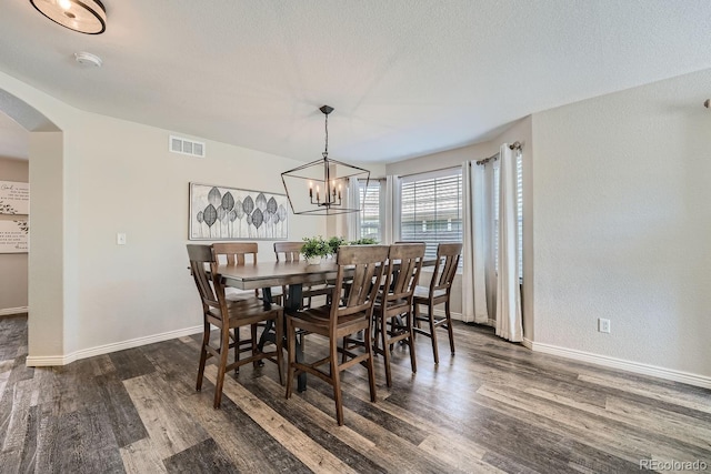 dining area with visible vents, baseboards, a chandelier, dark wood-style floors, and arched walkways