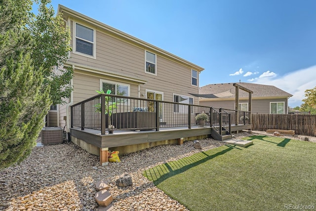 rear view of house featuring cooling unit, fence, a lawn, and a wooden deck