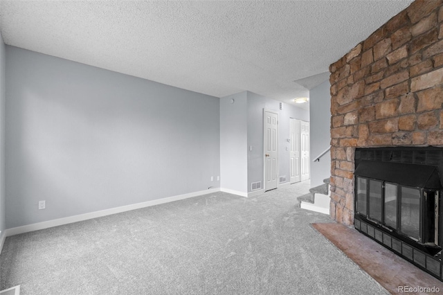 unfurnished living room with a fireplace, carpet, and a textured ceiling