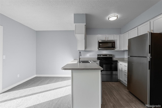 kitchen featuring a textured ceiling, stainless steel appliances, sink, a center island with sink, and white cabinetry