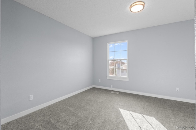 carpeted empty room featuring a textured ceiling