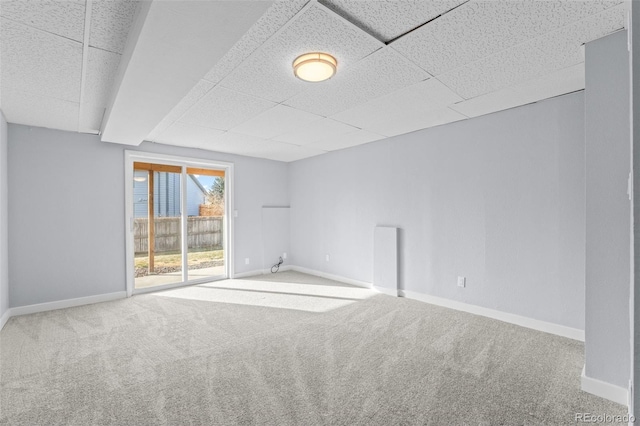 unfurnished room with a paneled ceiling and carpet floors