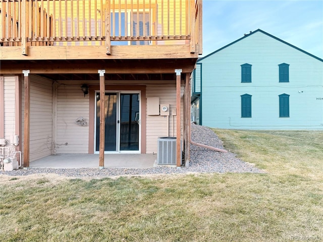 rear view of house featuring central air condition unit, a yard, and a patio