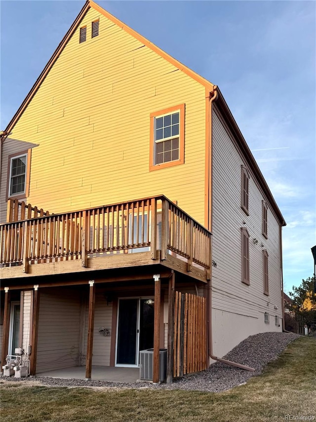 back of house featuring a patio area, a yard, cooling unit, and a wooden deck