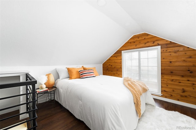 bedroom featuring wooden walls, lofted ceiling, and dark hardwood / wood-style floors