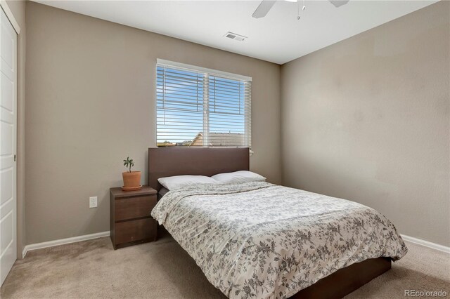 bedroom with baseboards, visible vents, ceiling fan, and light colored carpet