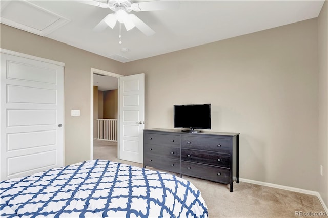 carpeted bedroom featuring attic access, baseboards, and ceiling fan