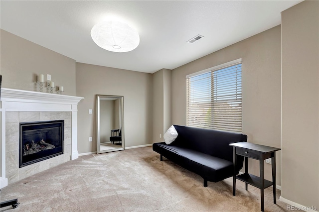 sitting room featuring a tile fireplace, carpet flooring, visible vents, and baseboards