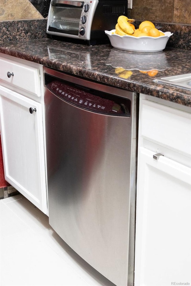 details featuring dark stone countertops, white cabinetry, and stainless steel dishwasher