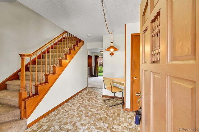 stairway with baseboards, a textured ceiling, and carpet