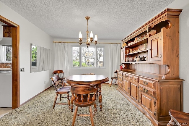 dining room with a chandelier, a textured ceiling, and light colored carpet