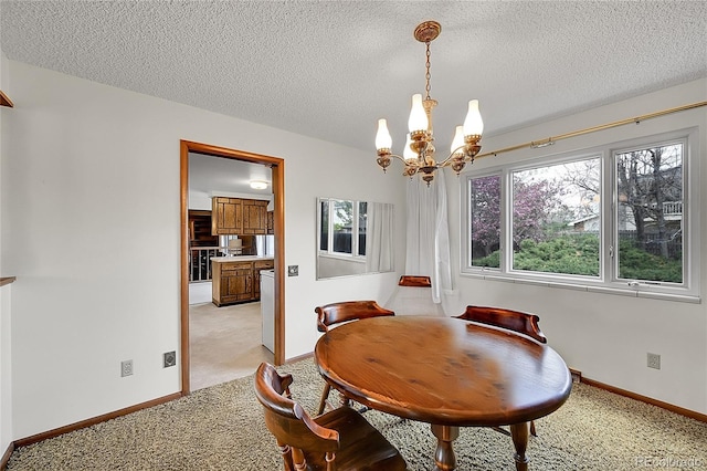 dining area featuring a chandelier, light carpet, baseboards, and a textured ceiling