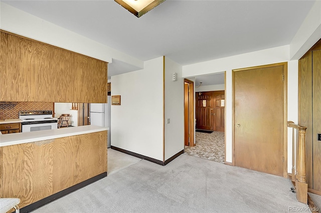 kitchen with white appliances, light colored carpet, brown cabinets, light countertops, and backsplash