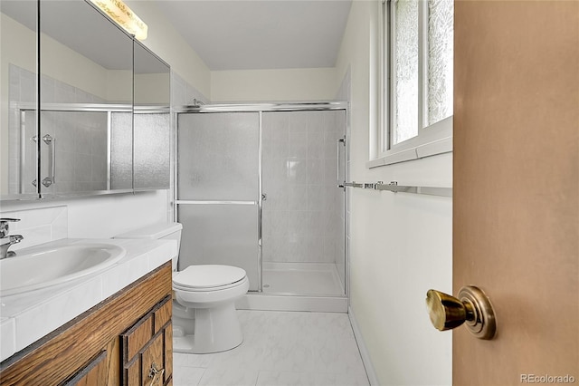 bathroom with toilet, a tile shower, and vanity