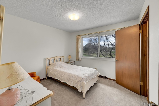bedroom featuring carpet, a textured ceiling, and baseboards