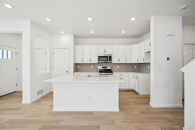 kitchen featuring a sink, visible vents, tasteful backsplash, and appliances with stainless steel finishes