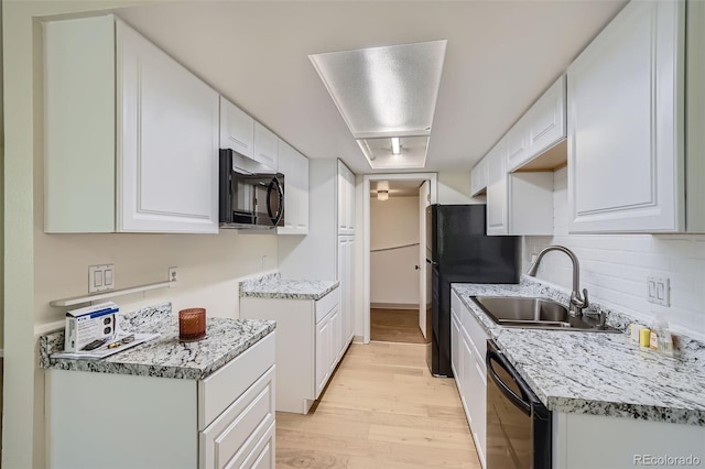 kitchen featuring light hardwood / wood-style floors, white cabinets, black appliances, and sink