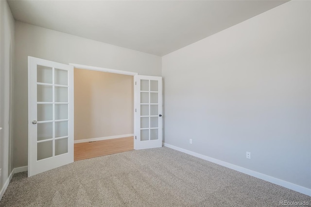 carpeted empty room featuring french doors