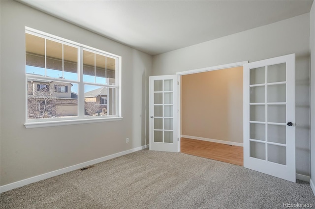 empty room with french doors and carpet