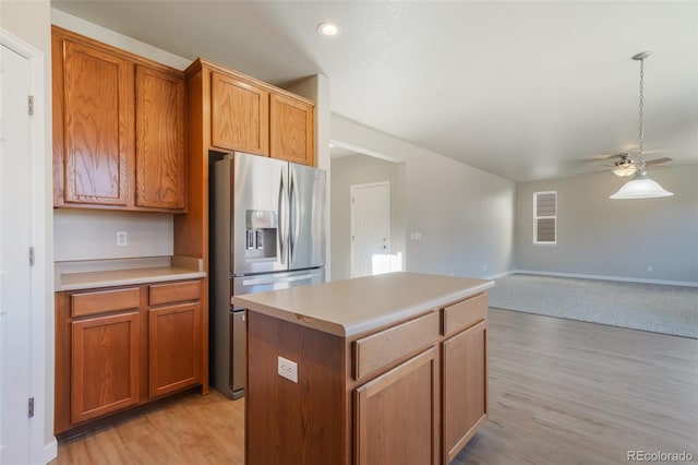 kitchen featuring stainless steel refrigerator with ice dispenser, ceiling fan, light hardwood / wood-style floors, and a kitchen island