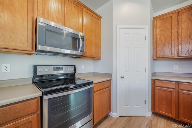 kitchen featuring stainless steel appliances and light hardwood / wood-style flooring