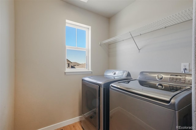 laundry room featuring separate washer and dryer and light wood-type flooring