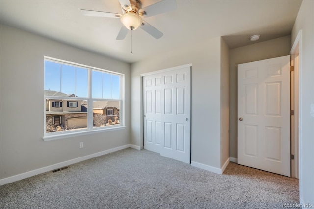 unfurnished bedroom featuring ceiling fan, a closet, and light carpet