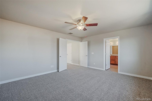 unfurnished bedroom with ceiling fan, light colored carpet, and connected bathroom