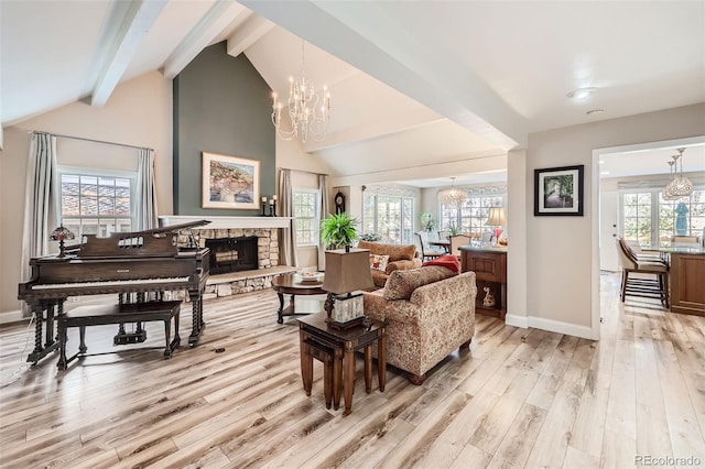 sitting room featuring vaulted ceiling with beams, a stone fireplace, light wood-type flooring, and a wealth of natural light