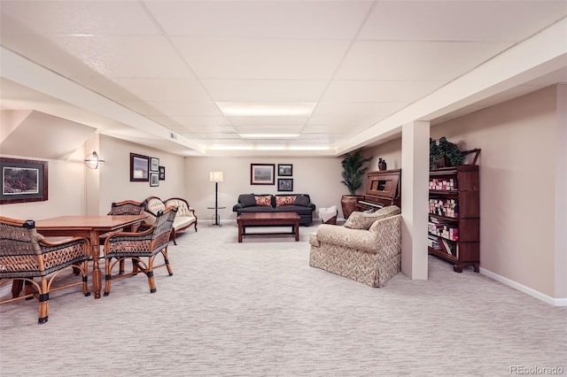 living room featuring carpet flooring and a drop ceiling