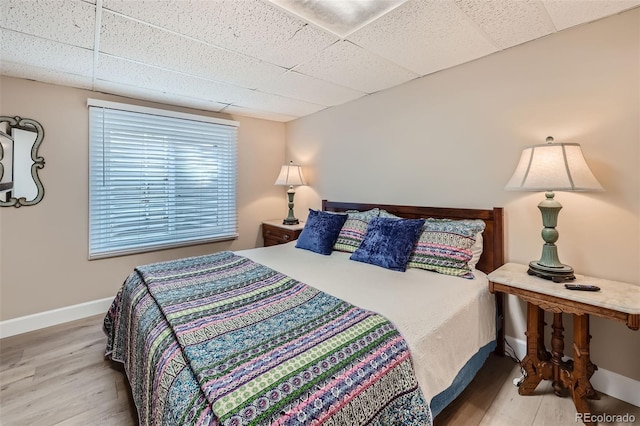 bedroom featuring a paneled ceiling and hardwood / wood-style floors