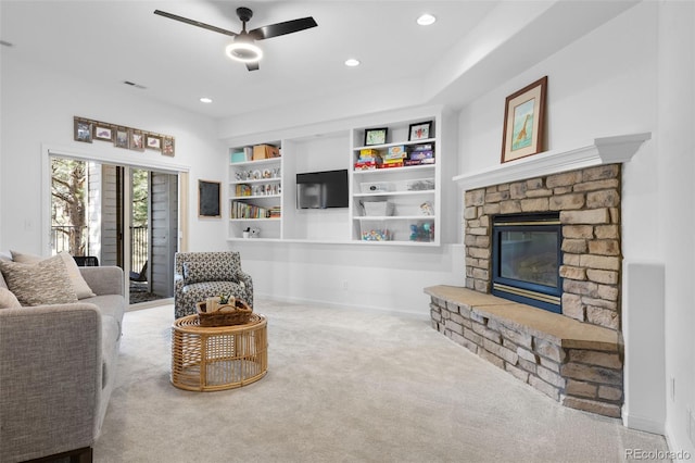 living room featuring a ceiling fan, recessed lighting, a stone fireplace, carpet flooring, and baseboards